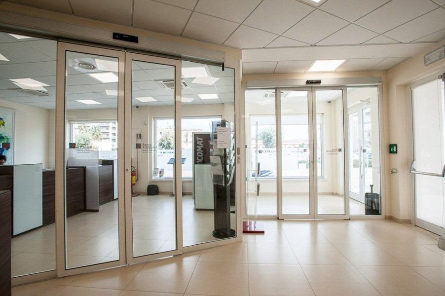 Una grande stanza con molte finestre e porte scorrevoli in vetro.