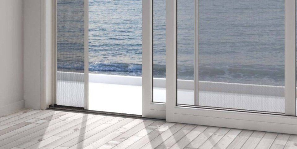 Una camera con vista sull'oceano tramite una porta scorrevole in vetro.