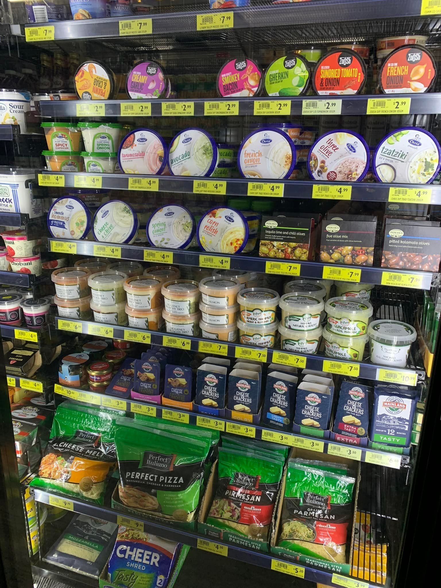 A grocery store refrigerator filled with a variety of food items.