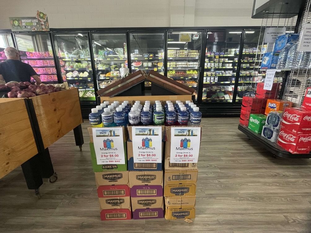 A Woman Is Holding A Shopping Basket In A Grocery Store — Smith Street Supermarket In Darwin City, NT 