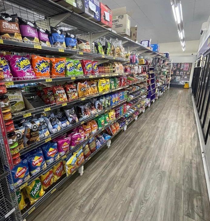 A long aisle of a grocery store filled with lots of snacks. — Smith Street Supermarket In Darwin City, NT 