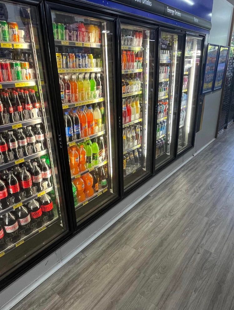 A row of refrigerators filled with sodas and other beverages — Smith Street Supermarket In Darwin City, NT 