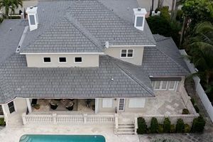 An aerial view of a large house with an asphalt shingle roof replacement