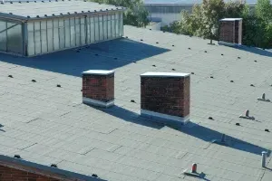 An aerial view of a large house with an asphalt shingle roof replacement