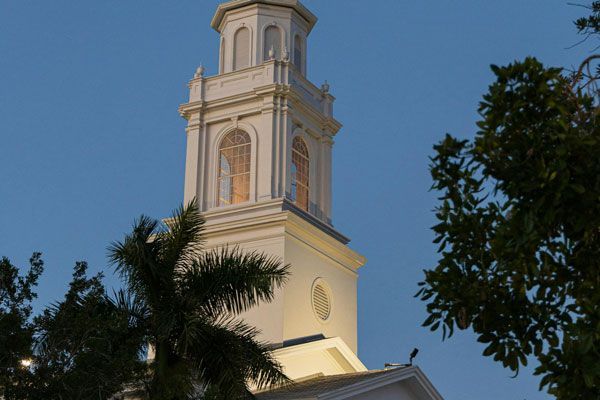 A very tall white building with a clock tower