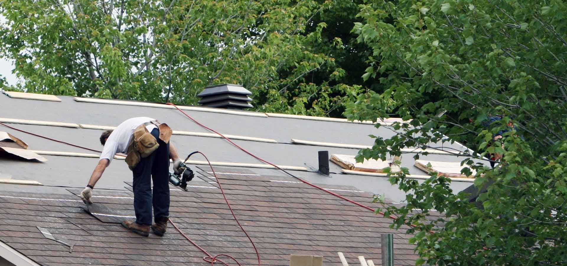 A man is working on the roof of a house.