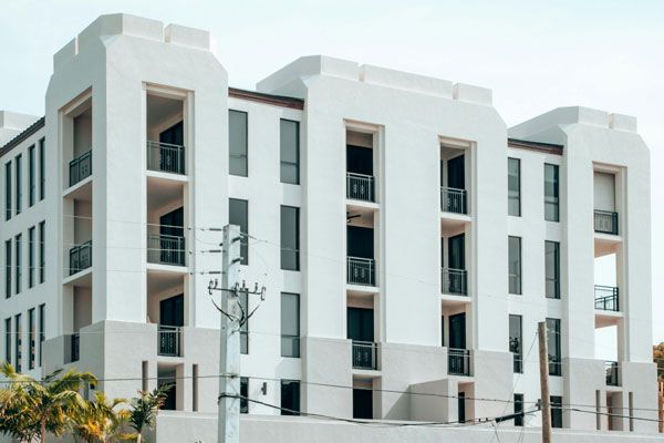 A large white condo building with a lot of windows and balconies.