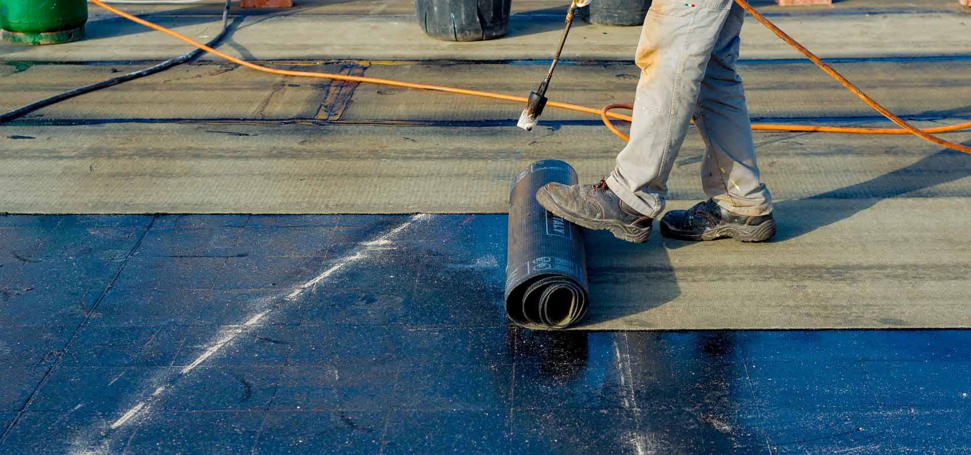 A person is working on a roof with a tool.