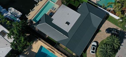 An aerial view of a house with a pool and a car parked in front of it.