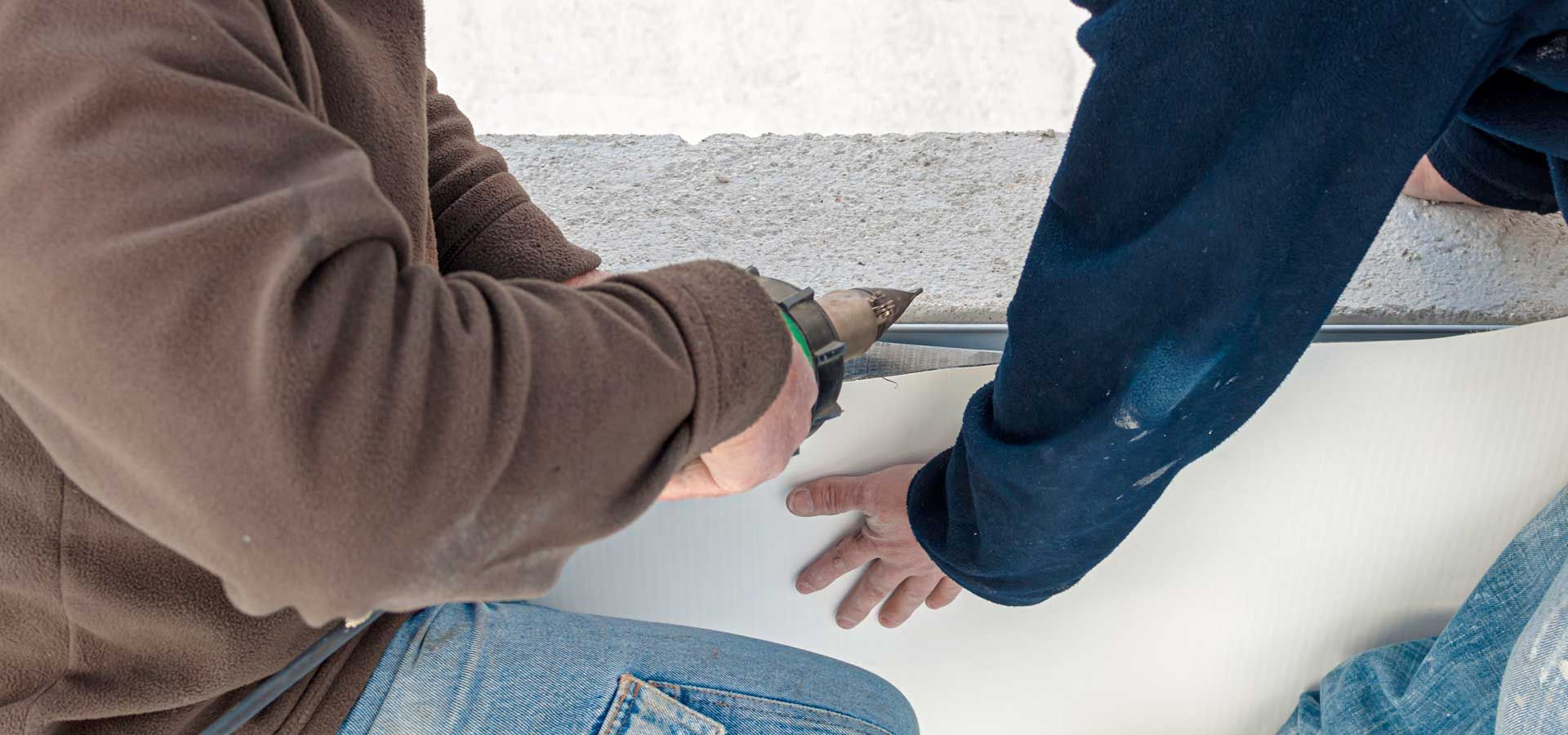 A man is installing shingles on a roof.