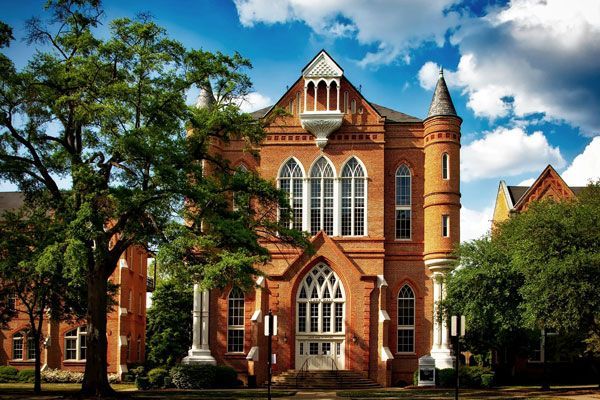 A large red brick building with a tree in front of it