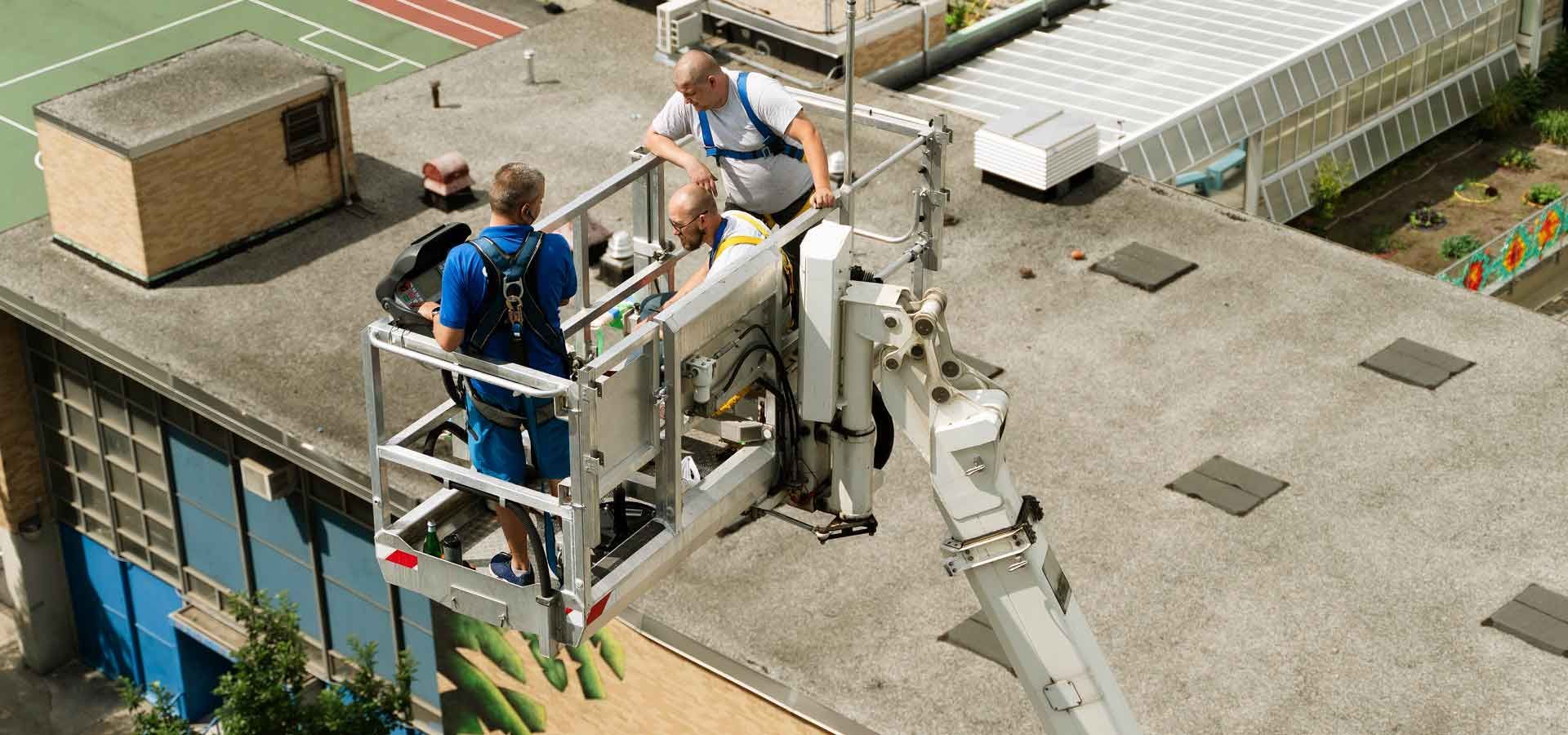 A group of men are working on the roof of a building.