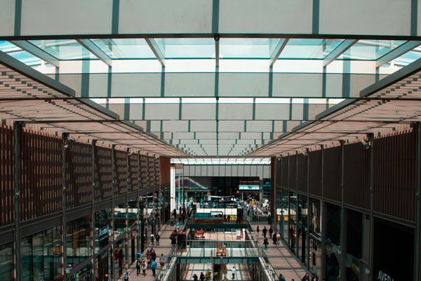 A large building with a lot of windows and people walking through it.