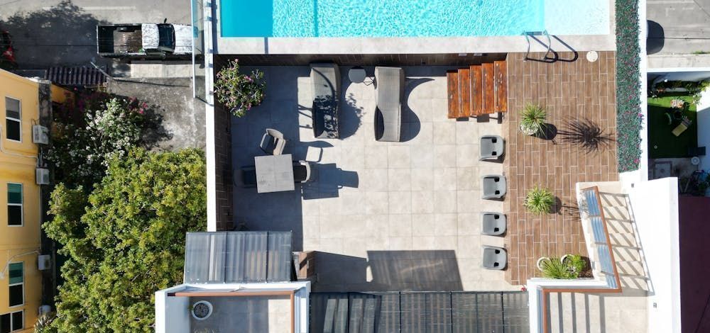 An aerial view of a house with a swimming pool and a patio.