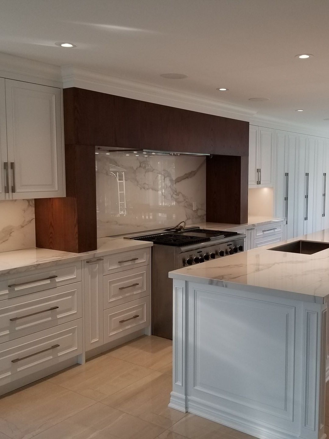 A kitchen with blue cabinets , a stove , a sink , and a window.