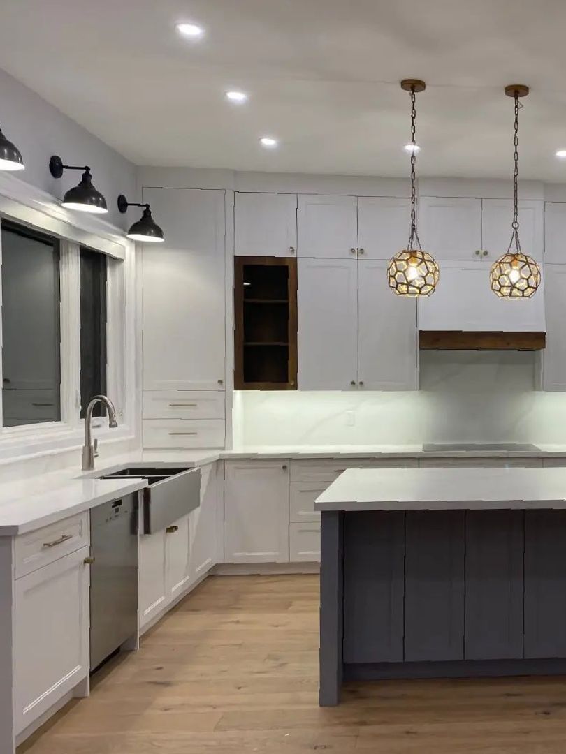 A modern kitchen with gray cabinets and a marble floor.