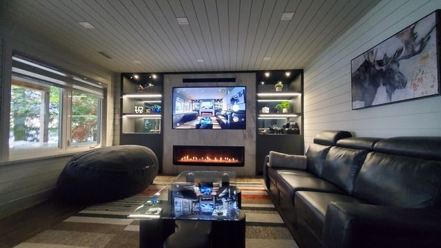 A living room with a couch , fireplace and television.