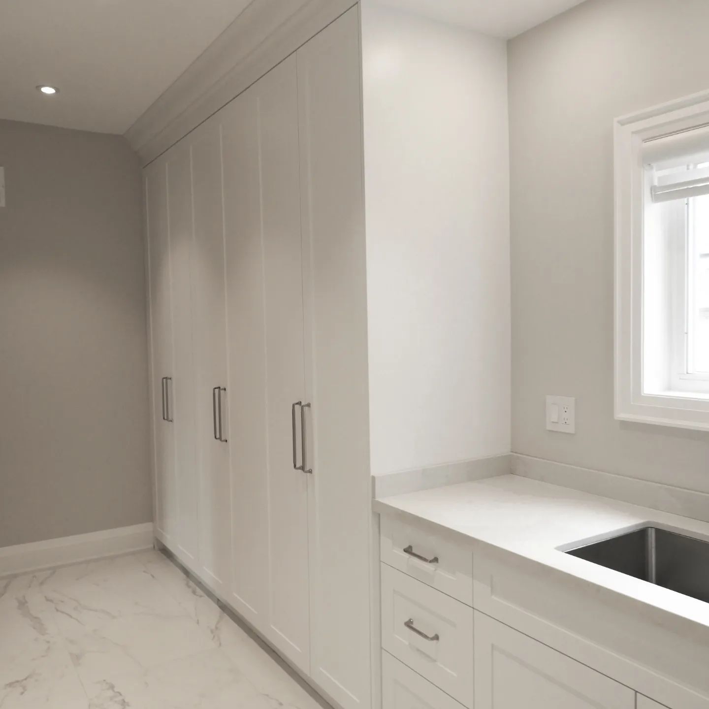A laundry room with white cabinets and a sink