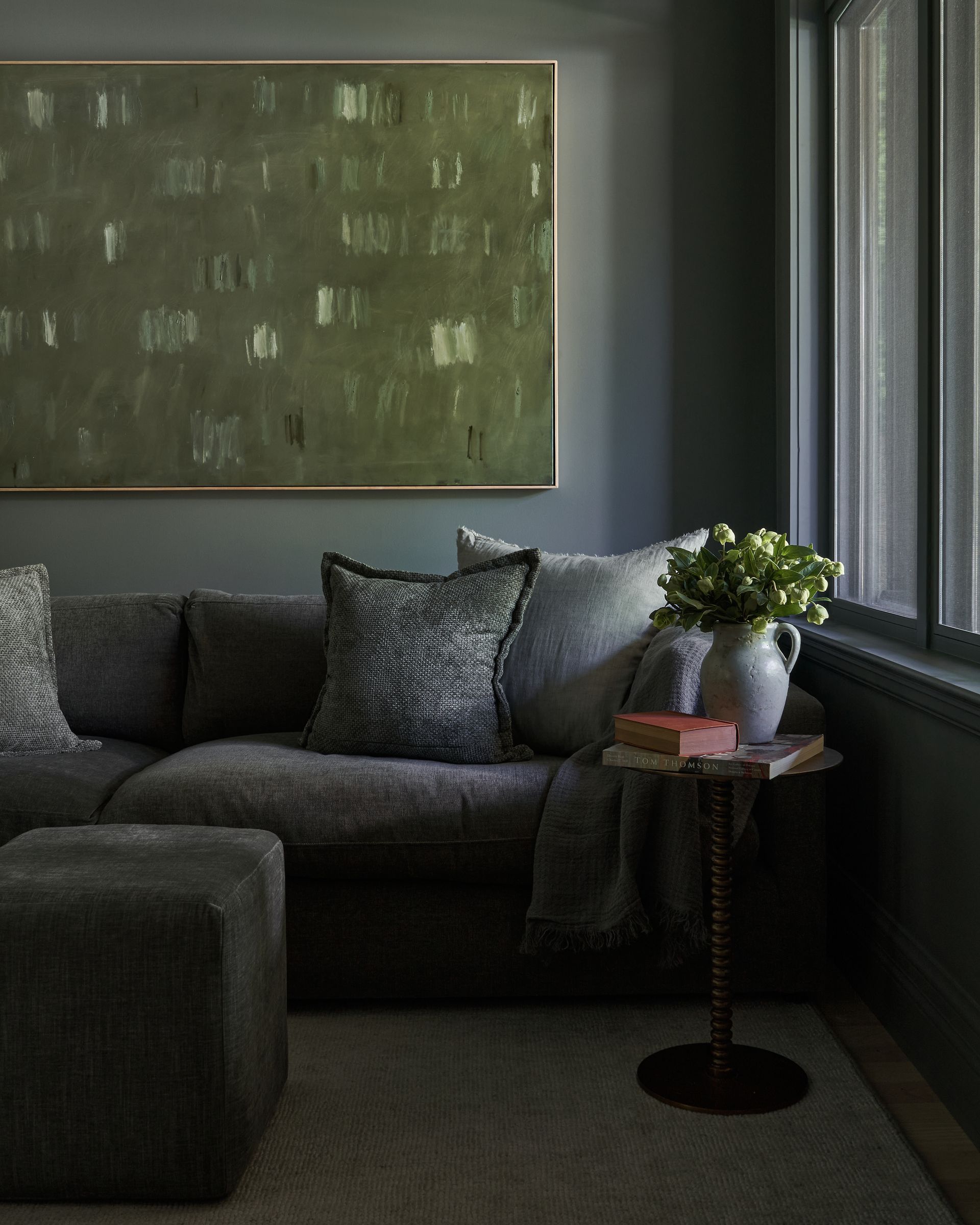 There is a painting on the wall above the couch in the living room.