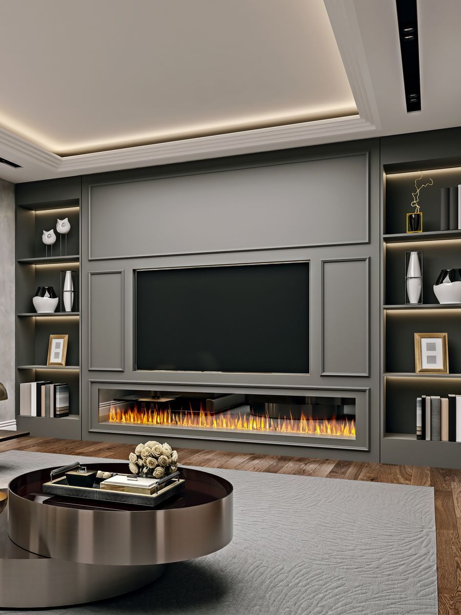 Modern living room with a gray entertainment unit, including a fireplace and built-in shelves, and a large television. A round coffee table sits in the foreground.