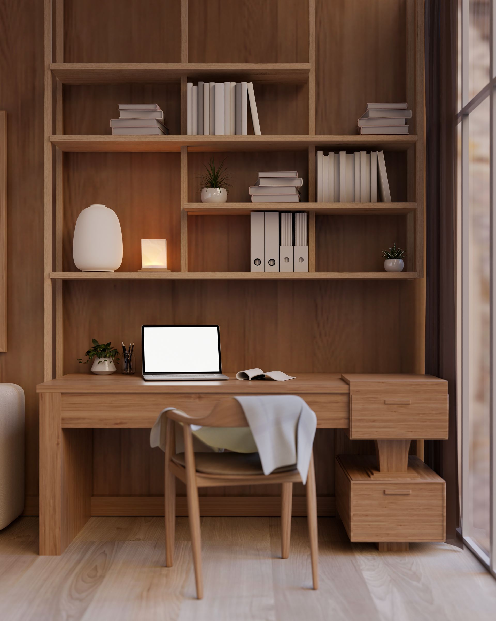 Wooden desk with built-in shelves, laptop, chair, and decor. Warm tones and natural light fill the home office space.
