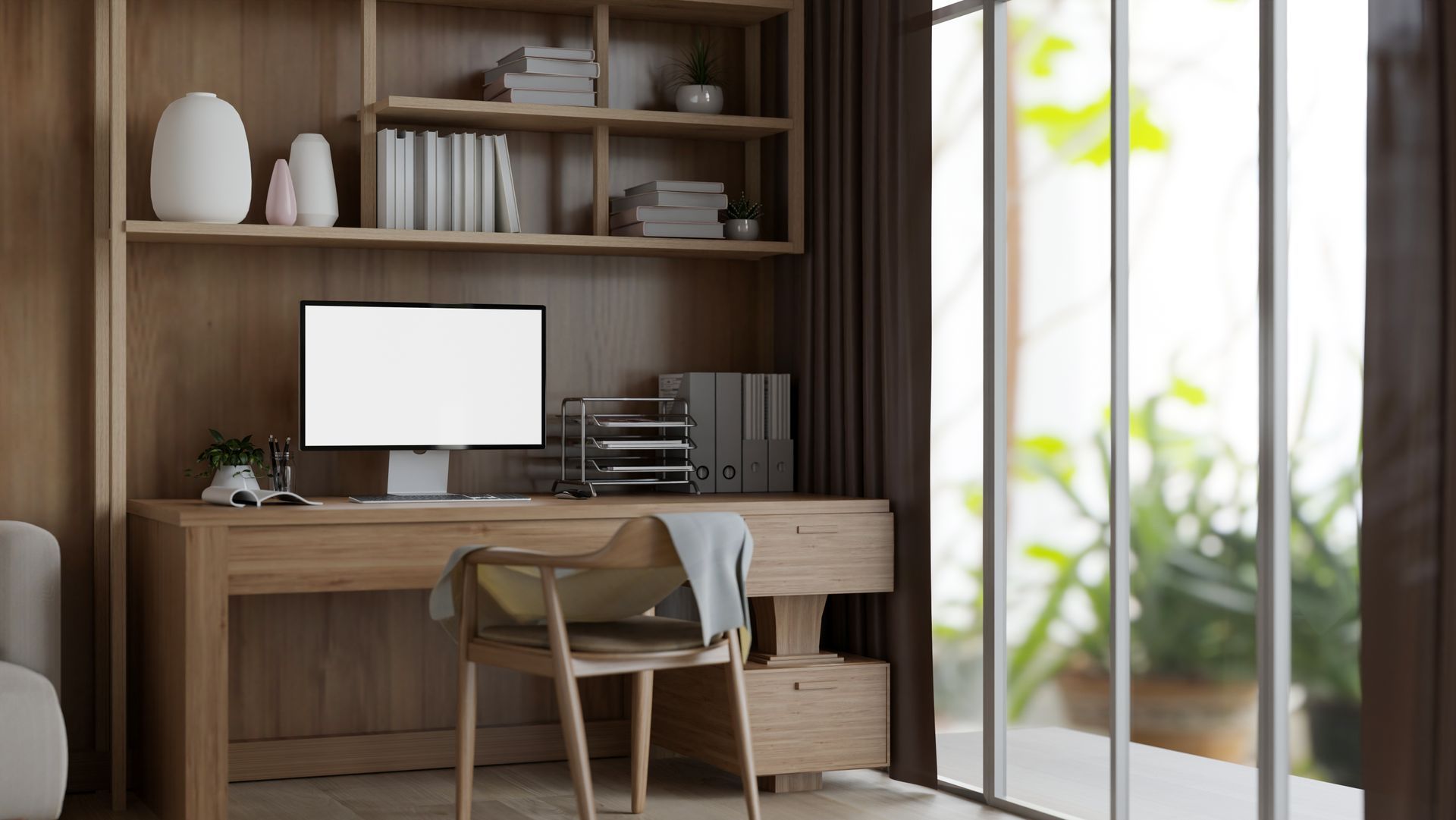 Wooden home office with built-in desk, bookshelf, and large window overlooking greenery. A monitor sits on the desk with a chair in front.