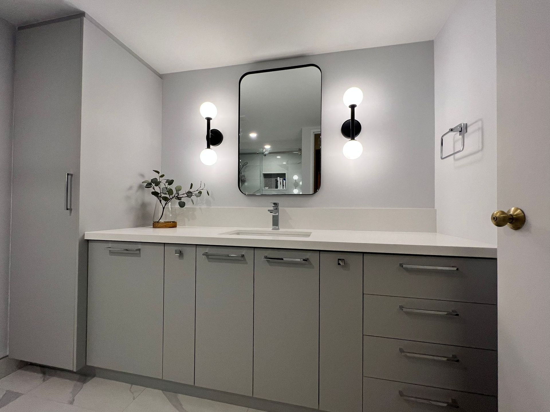 A bathroom with a sink , mirror and cabinets.