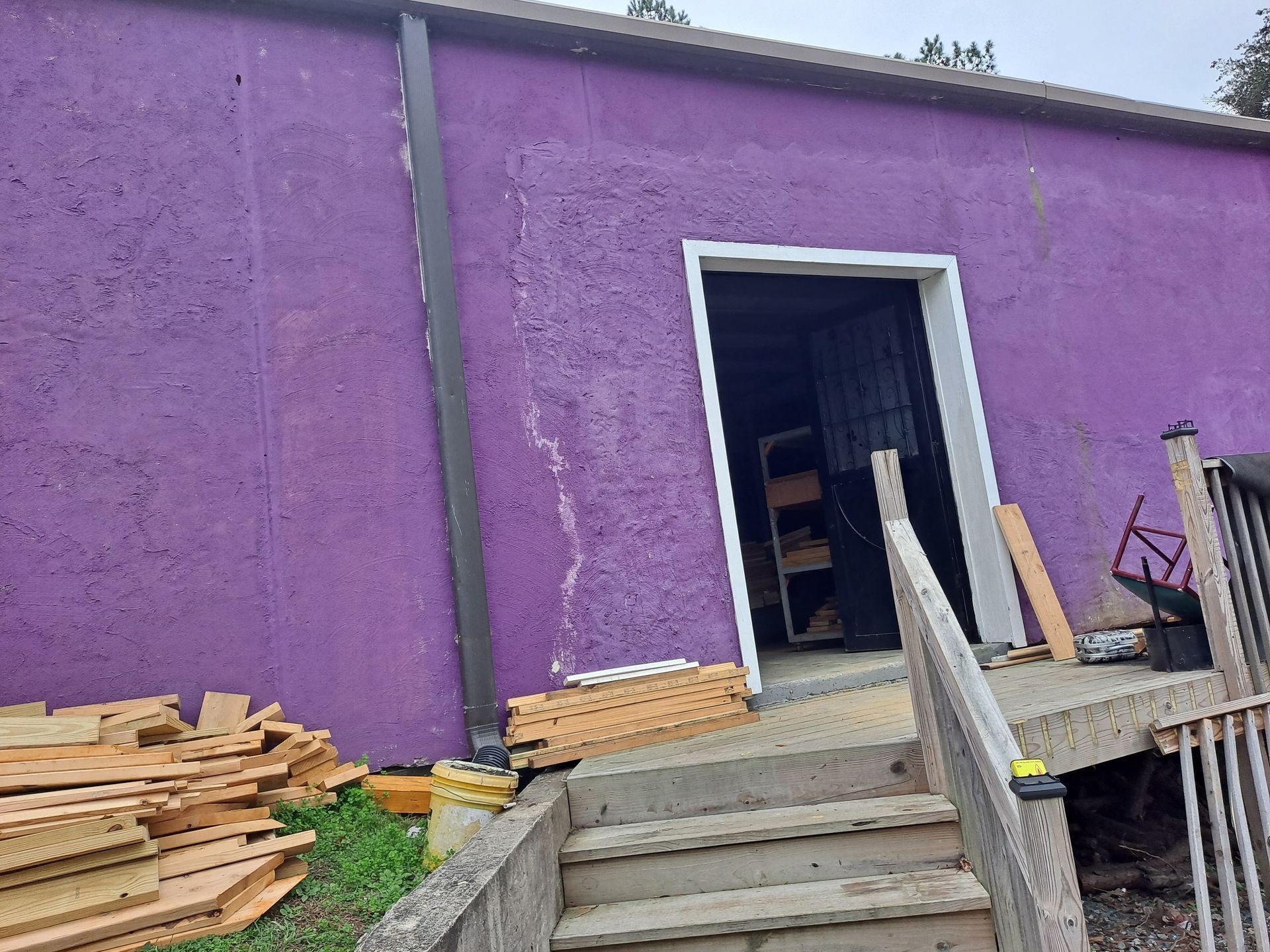 A purple building with stairs leading up to it and a door.