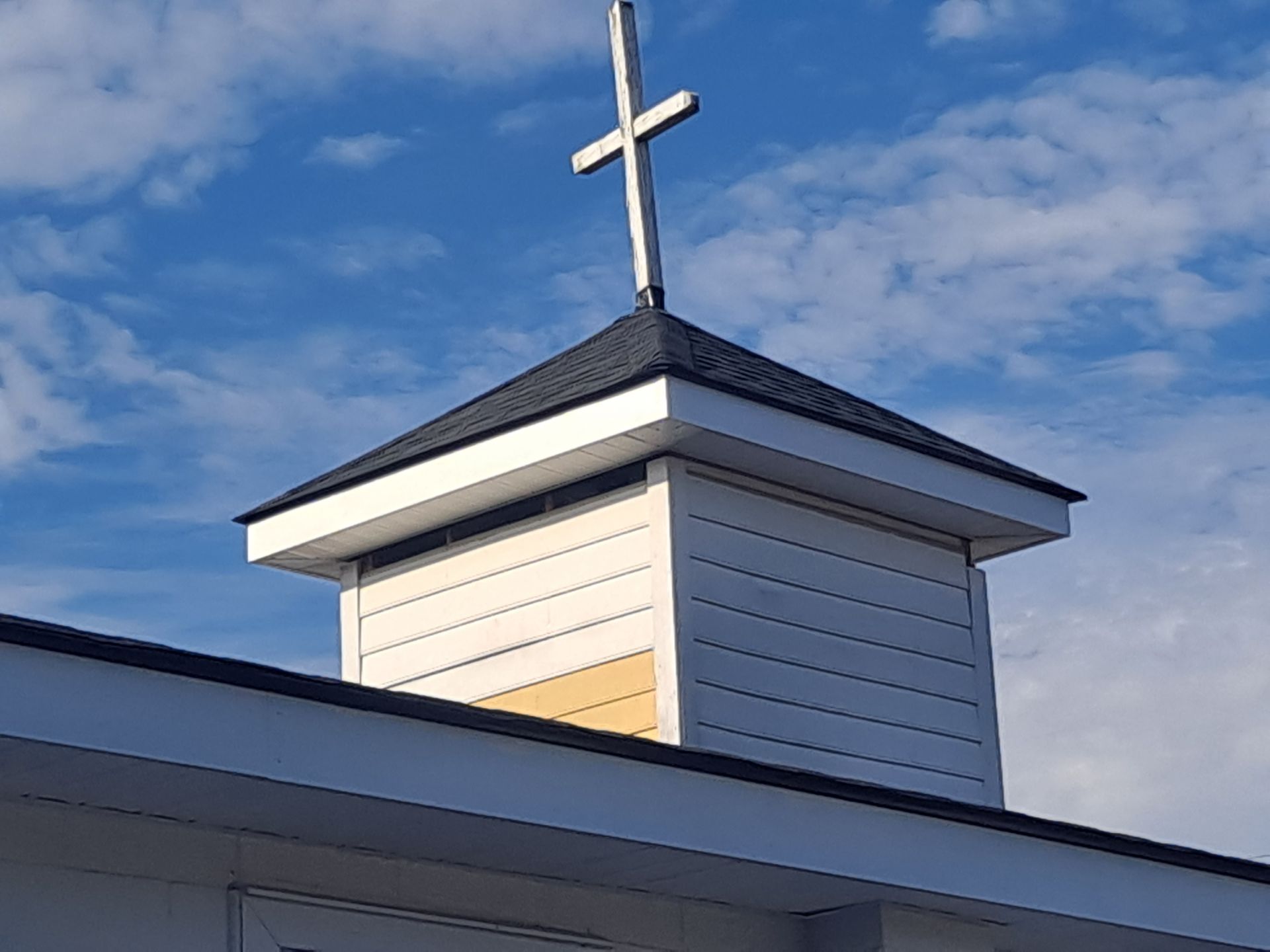 A church steeple with a cross on top of it.