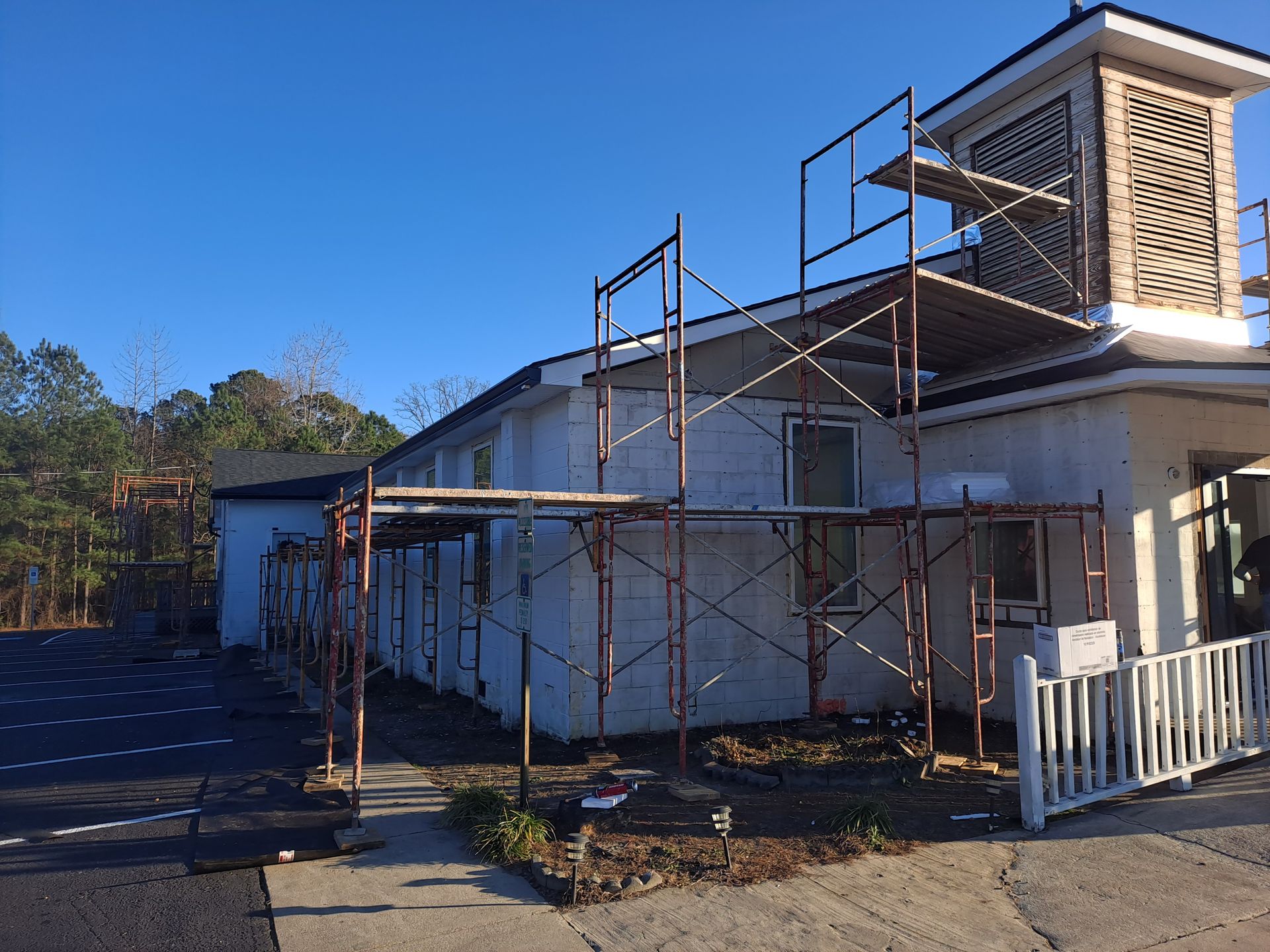 A house with scaffolding on the side of it is being painted.