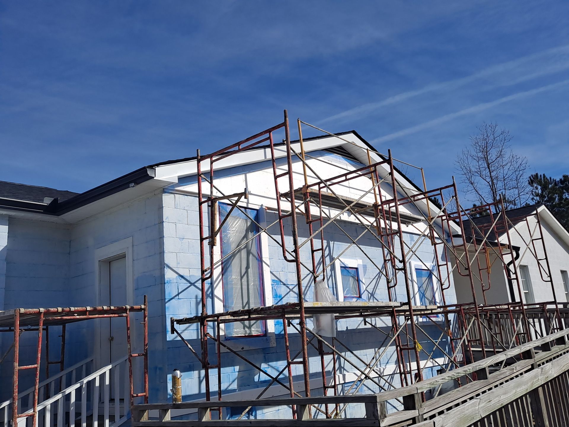 A house is being remodeled with scaffolding around it.
