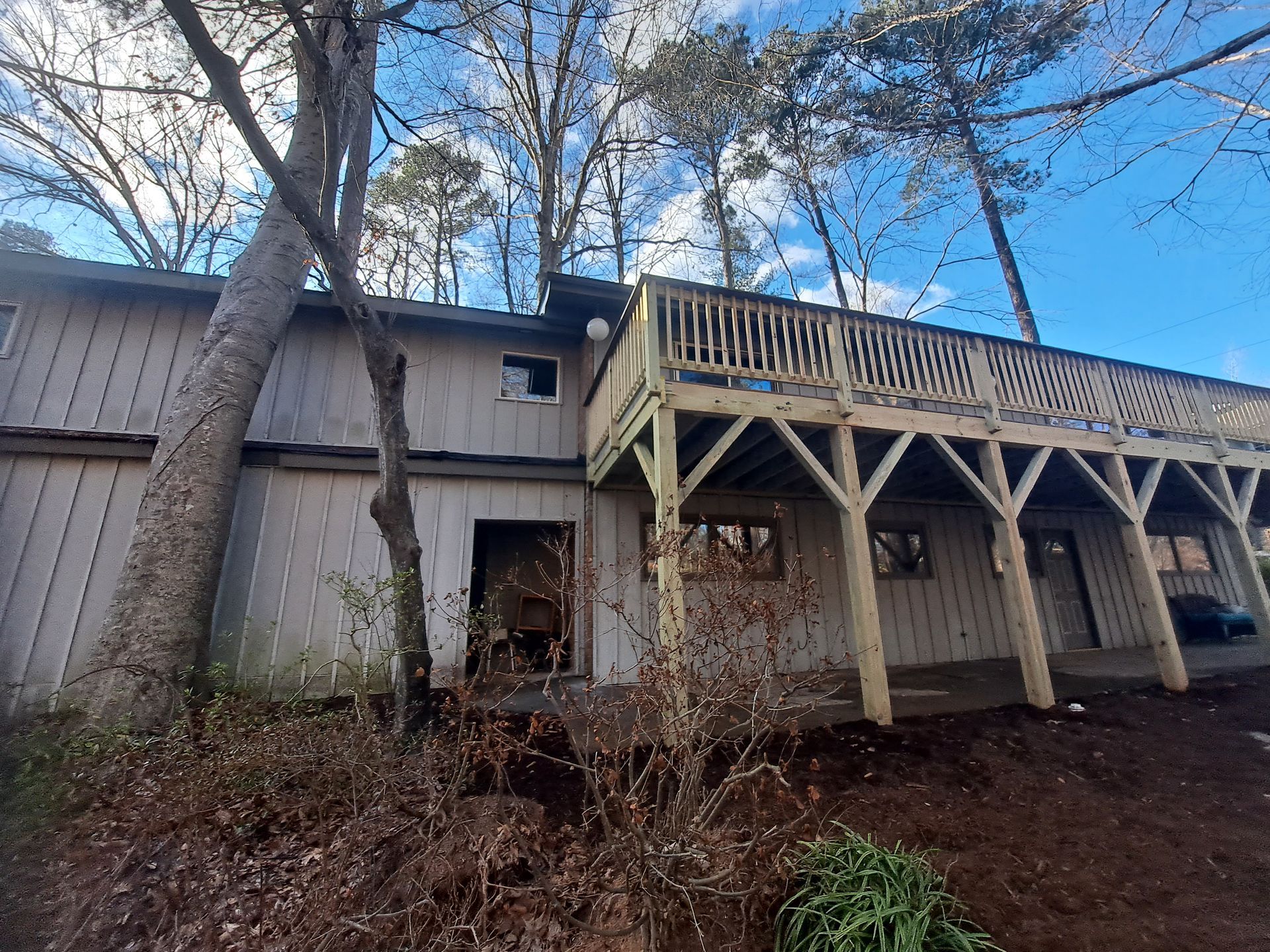 A house with a large deck and trees in the background