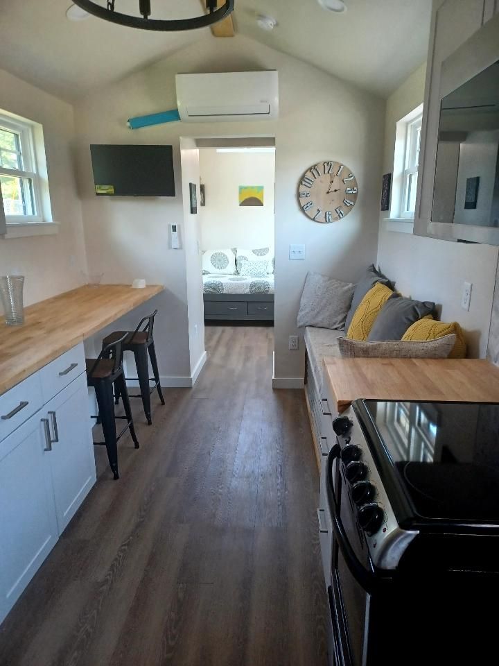 A kitchen with a stove and a clock on the wall.