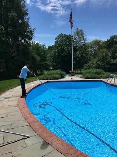 Worker cleaning the Pool — Pool Maintenance in Simsbury, CT