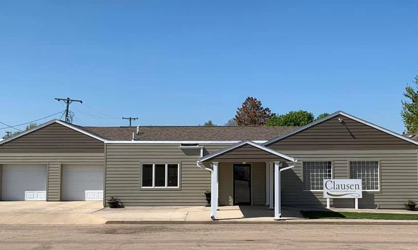 The front door of a house with a porch and plants in front of it.