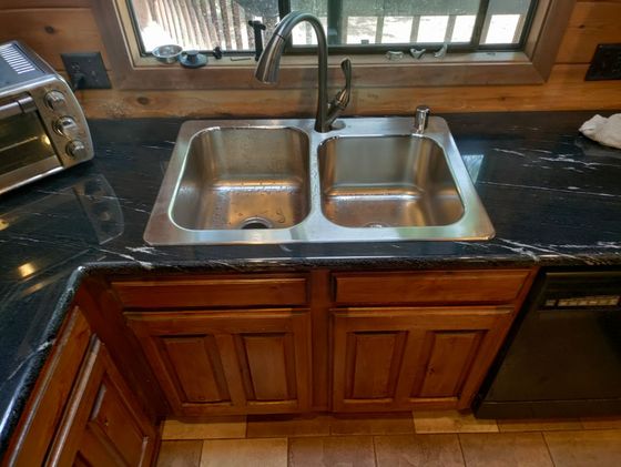 A kitchen sink is sitting on top of a granite counter.