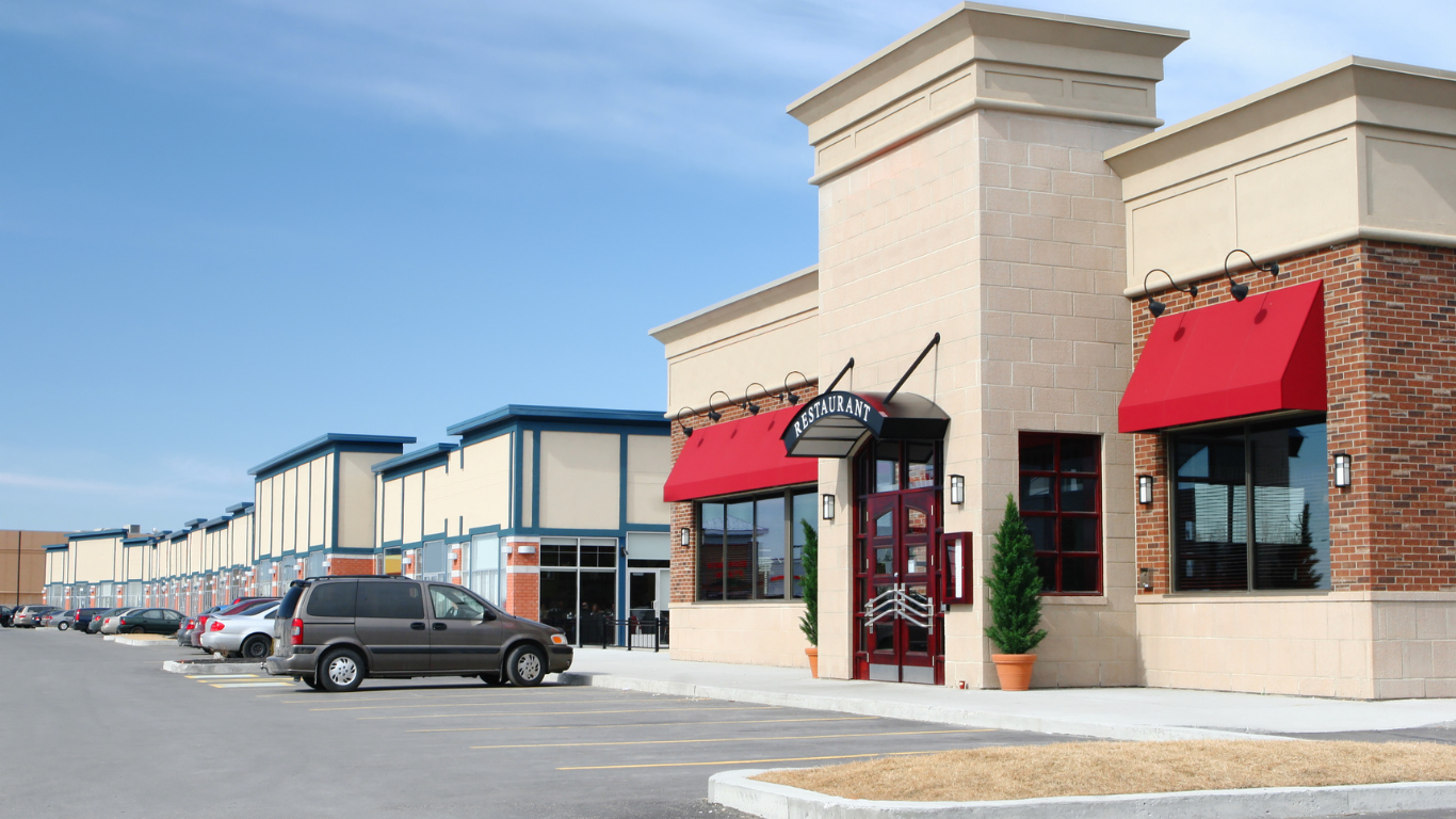 A van is parked in front of a building with red awnings.