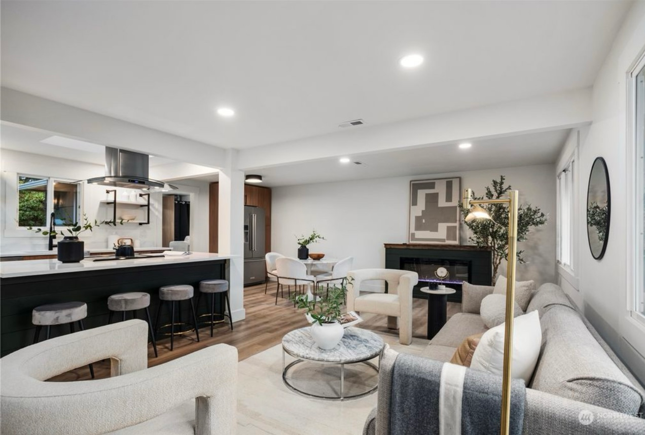 Open-concept living space with kitchen, dining, and sitting areas; neutral tones with modern furniture.