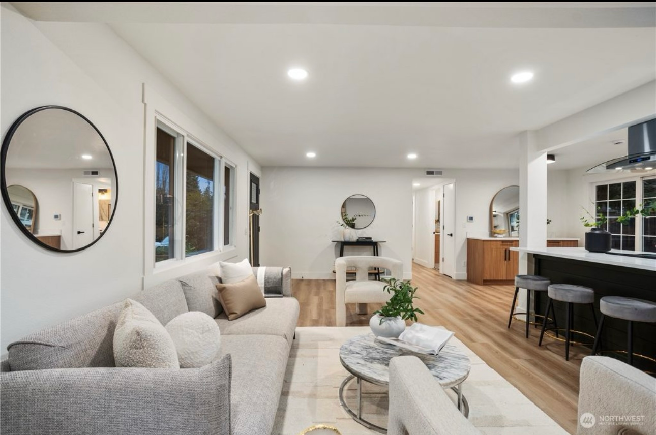 Living room with light wood floors, white walls, and a modern design.