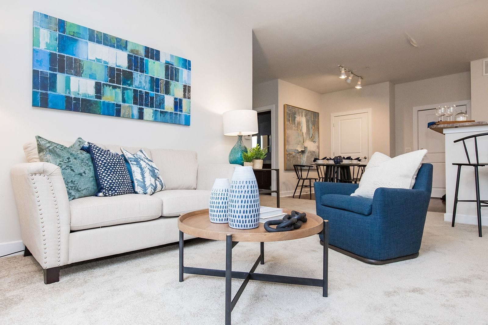 a living room with a couch , chair , coffee table and painting on the wall  at Verde Howard Square West..