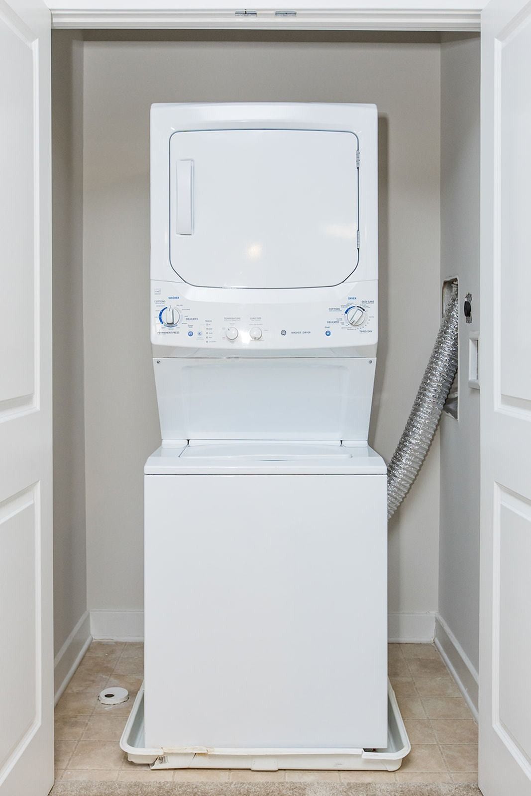 a washer and dryer are stacked on top of each other in a closet at Verde Howard Square West.