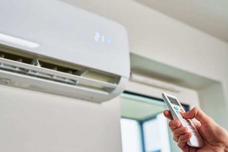 Hand Adjusting Temperature On Air Conditioner — St. George, UT — Peach Services LLC