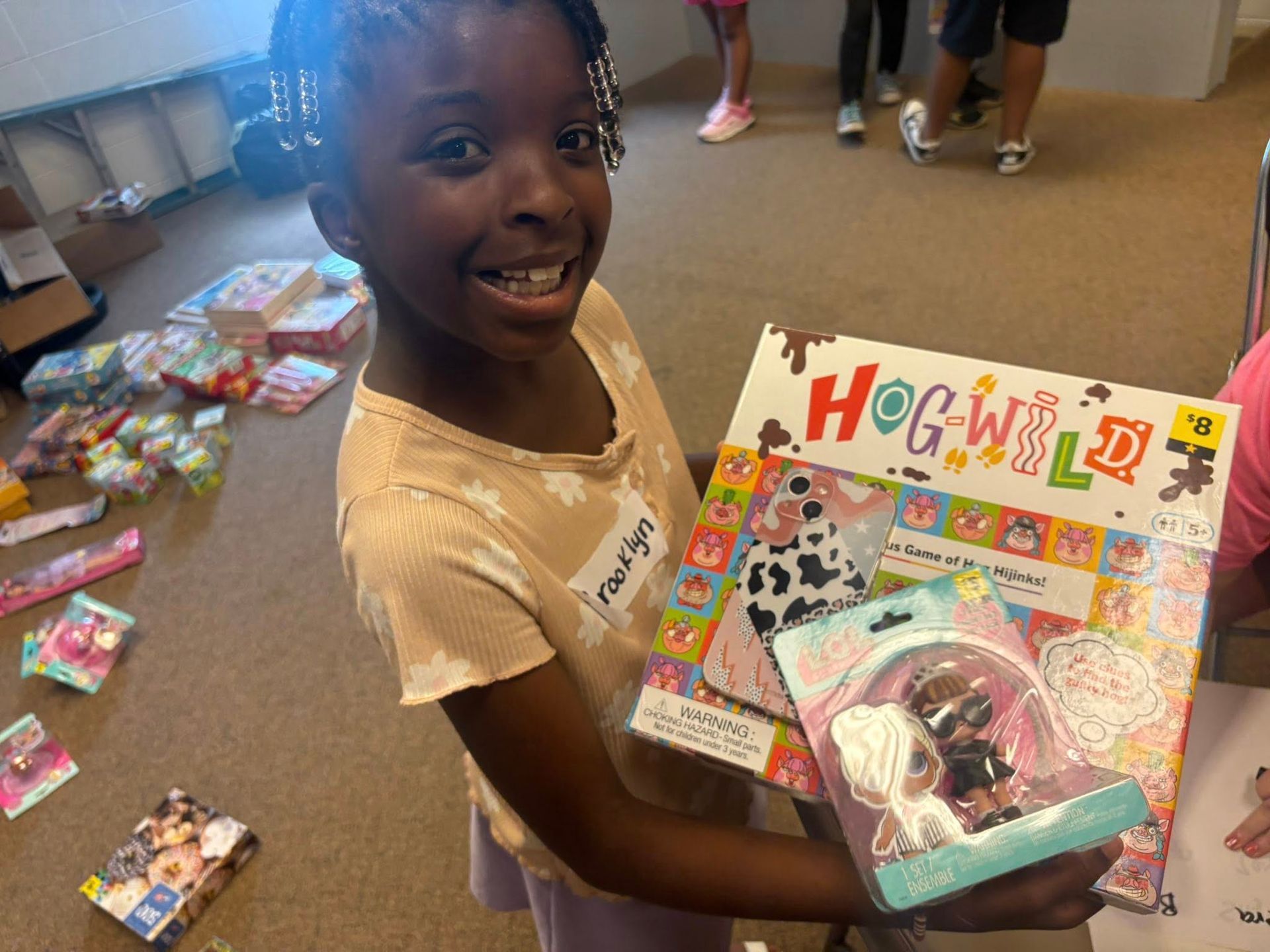 A young girl is holding a box of hogwarts cards.