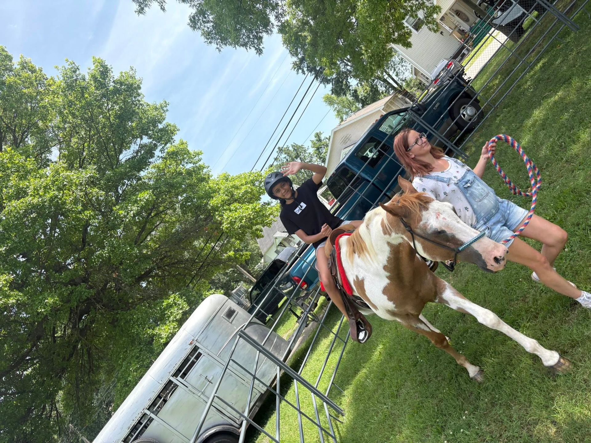 A woman is standing next to a brown and white horse.