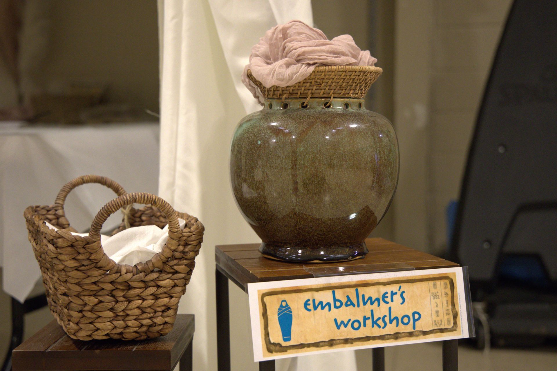 A sign that says embalmer 's workshop next to a vase