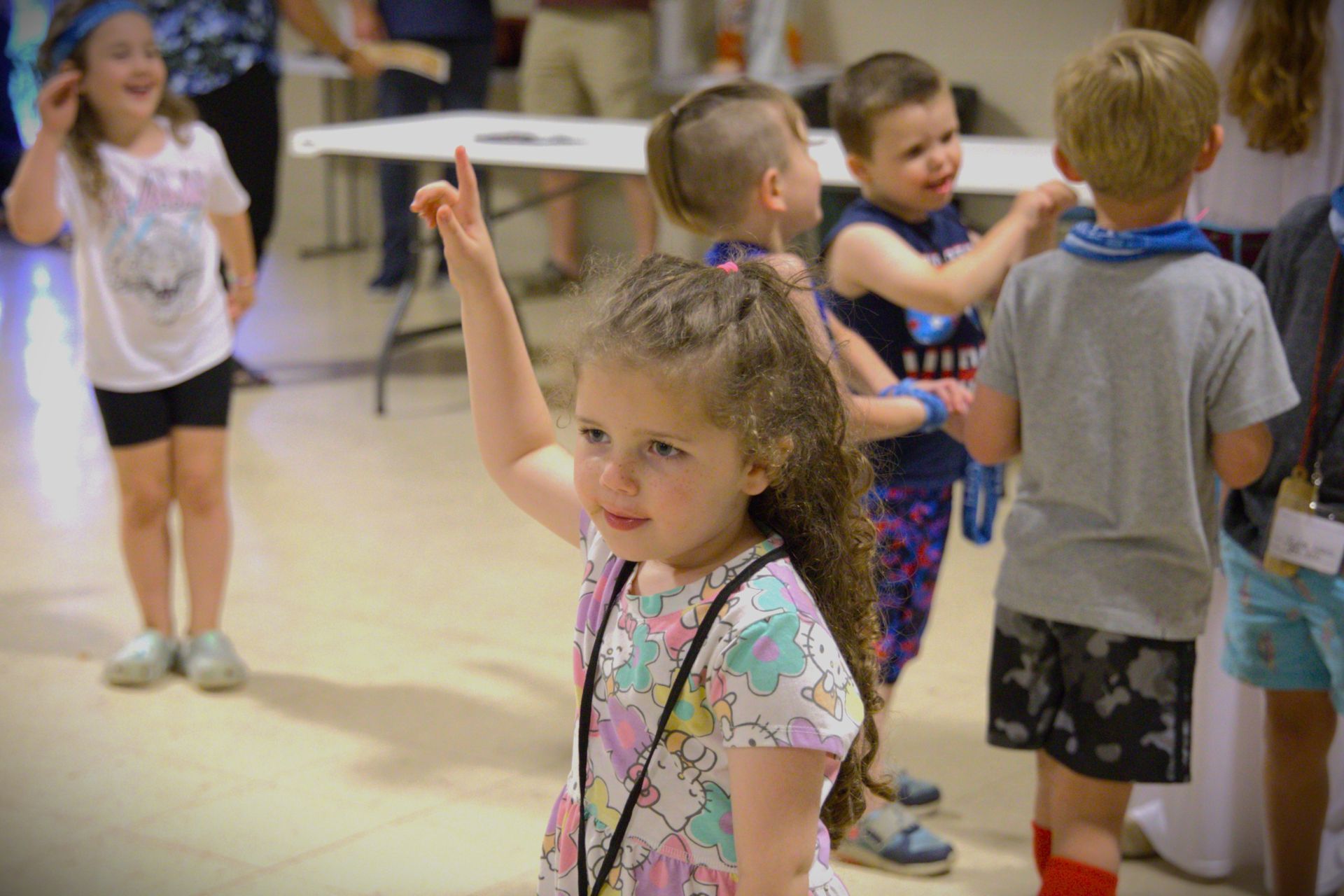 A group of children are standing around a table in a room.
