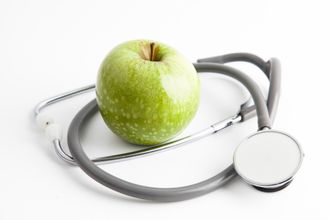 Stetoscopio e mela rappresentano la sana nutrizione controllata dal medico