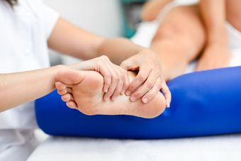 Medico pratica massaggio ai piedi in un centro di fisioterapia.