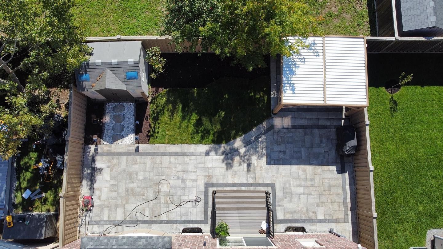 An aerial view of a backyard with a patio and a fence.