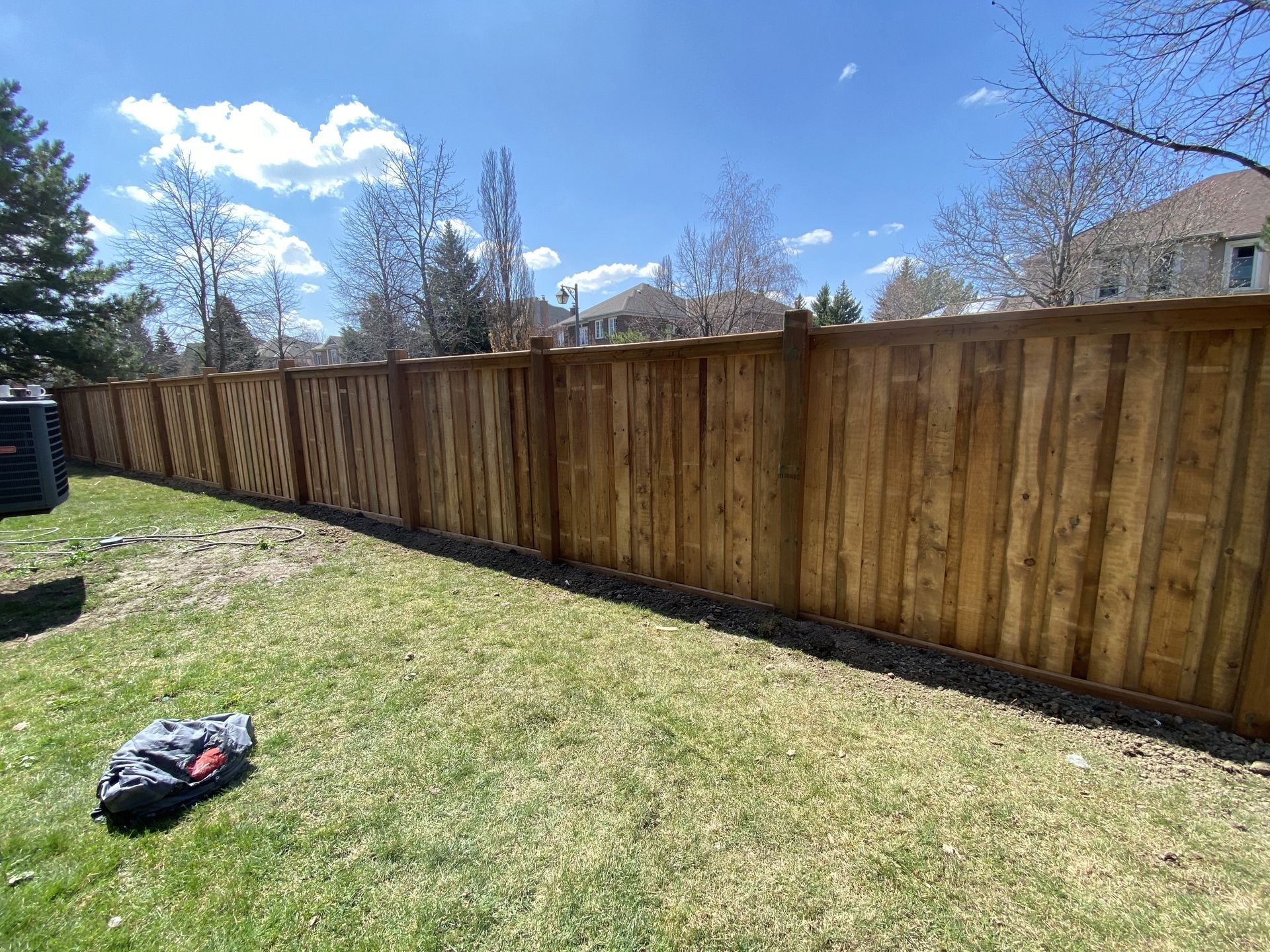 A wooden fence is sitting in the middle of a lush green yard.